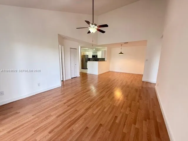 a view of a kitchen with wooden floor and a ceiling fan