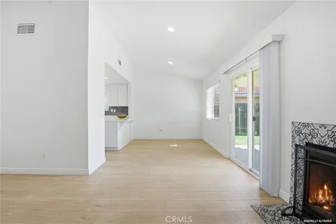 a view of an empty room with a fireplace and a window