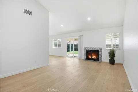 a view of an empty room with a fireplace and a window