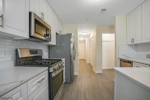 a kitchen with stainless steel appliances a stove a microwave a sink and cabinets