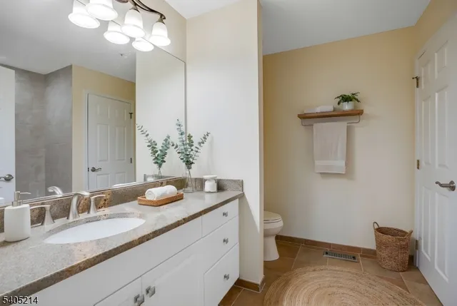 a bathroom with a granite countertop sink and a mirror