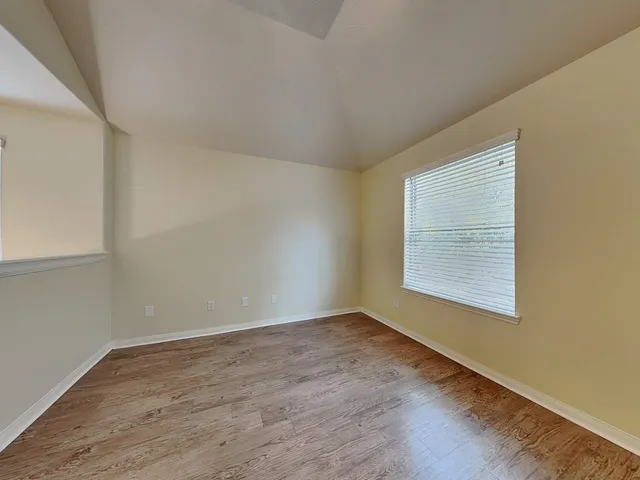 an empty room with wooden floor and closet