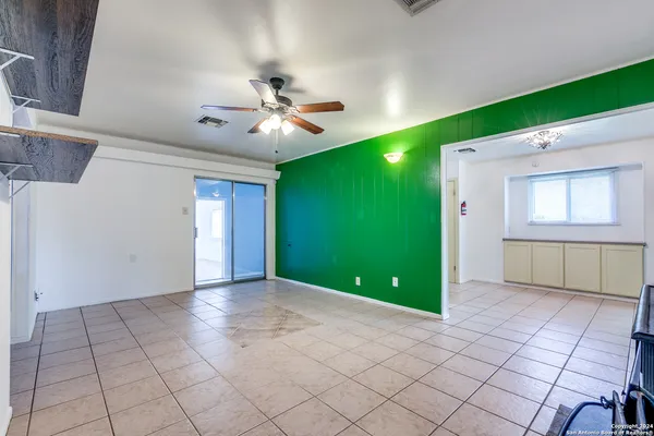 a view of an empty room with window and fan