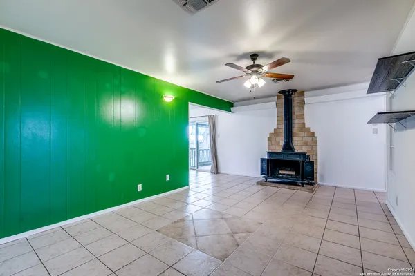 a view of an empty room with a window and a fireplace