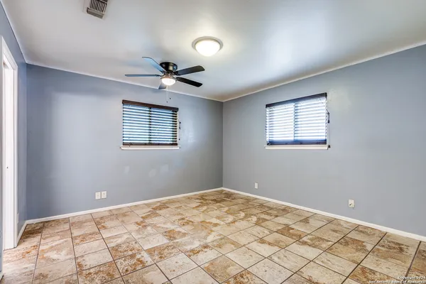 a view of a room that has a window and a ceiling fan