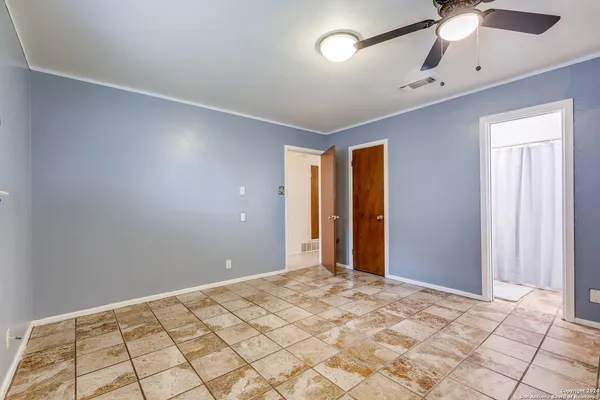 a view of a room with a ceiling fan and window