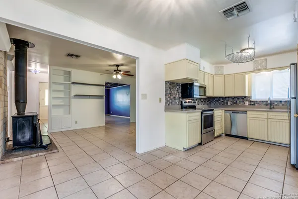 a kitchen with a refrigerator and a stove top oven