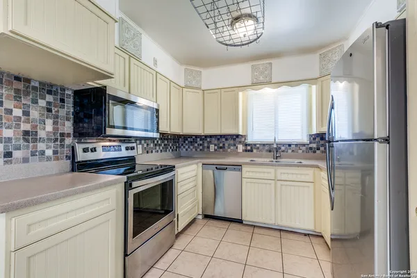 a kitchen with a stove a sink and a refrigerator