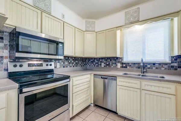 a kitchen with cabinets stainless steel appliances a sink and a microwave