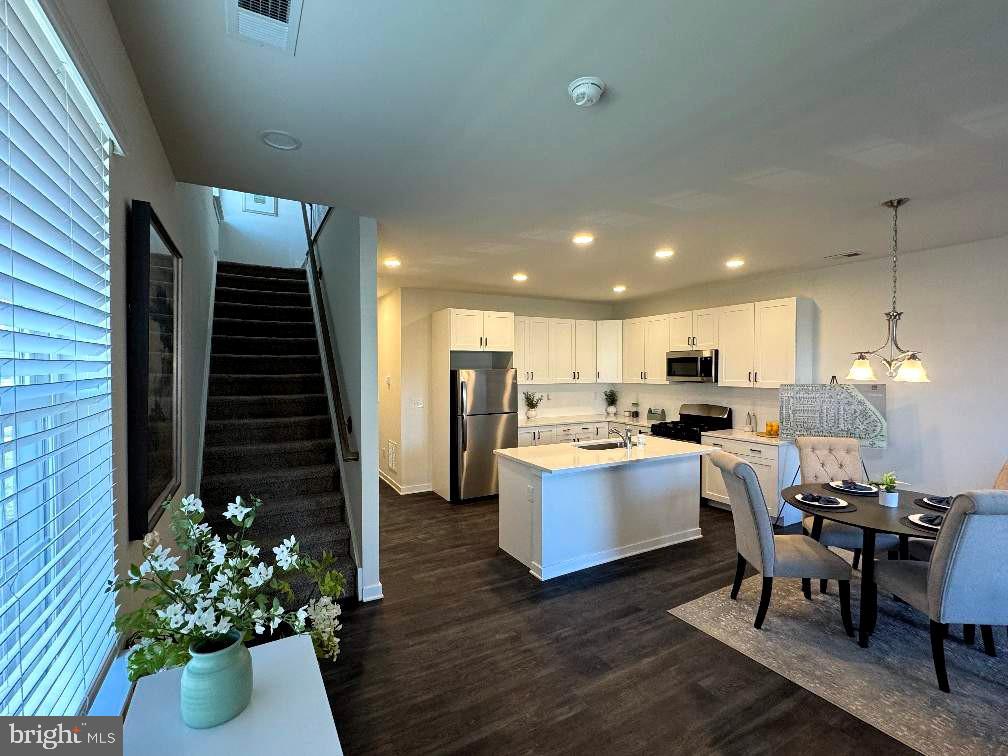 607 Ruth Way Dover, DE 19904 - Photo 3 of 10 a living room with kitchen island furniture and a potted plant