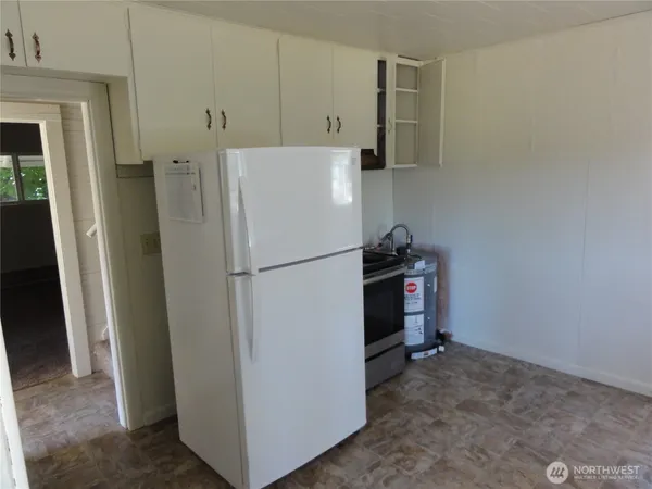 a white refrigerator freezer and a stove sitting inside of a kitchen