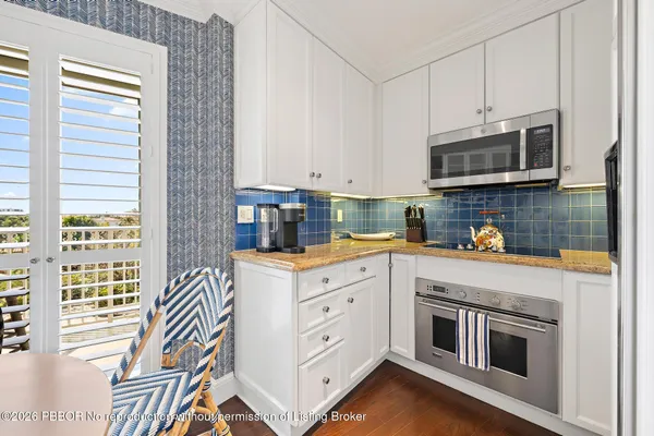 a kitchen with stainless steel appliances white cabinets and a stove top oven
