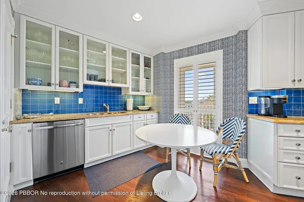 a kitchen with a dining table chairs and large window