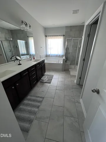 a large bathroom with a double vanity sink a toilet a mirror and vanity