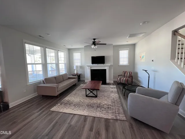 a living room with furniture a fireplace and a window