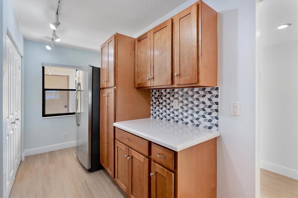 2900 Southwest 22nd Circle, Unit 221E Delray Beach, FL 33445 - Photo 12 of 43 a kitchen with stainless steel appliances granite countertop a refrigerator sink and cabinets