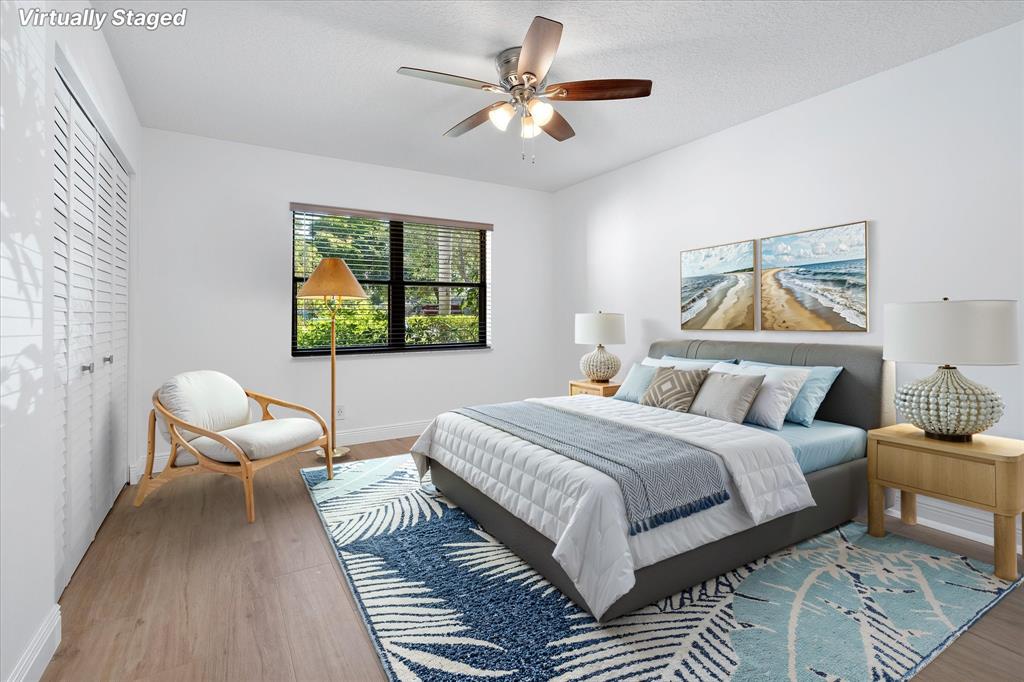 2900 Southwest 22nd Circle, Unit 221E Delray Beach, FL 33445 - Photo 18 of 43 a bedroom with a bed wooden floor and window