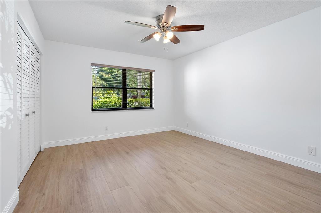 2900 Southwest 22nd Circle, Unit 221E Delray Beach, FL 33445 - Photo 19 of 43 wooden floor in an empty room with a window
