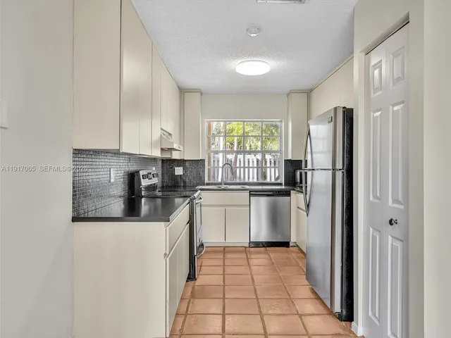 a kitchen with stainless steel appliances a cabinets and a stove top oven