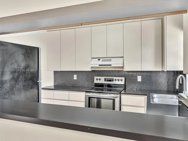 a kitchen with granite countertop white cabinets and white appliances