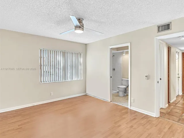 a view of an empty room with wooden floor