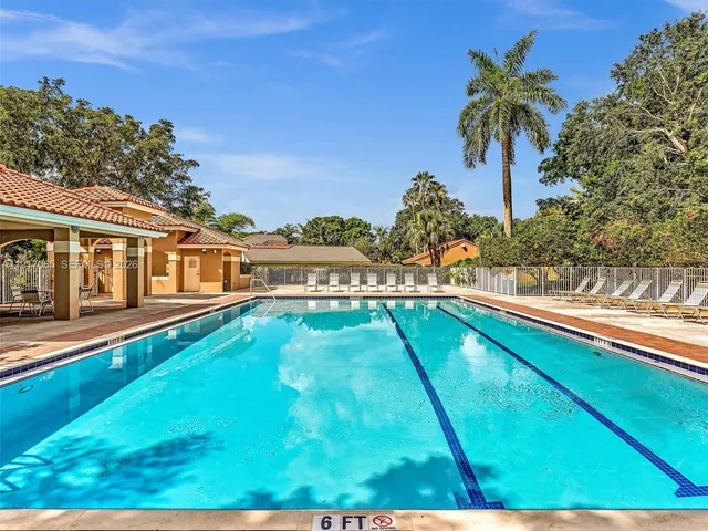 a view of sign board with yard and trees