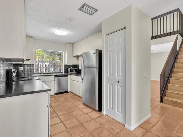 a kitchen with stainless steel appliances granite countertop a refrigerator and a stove