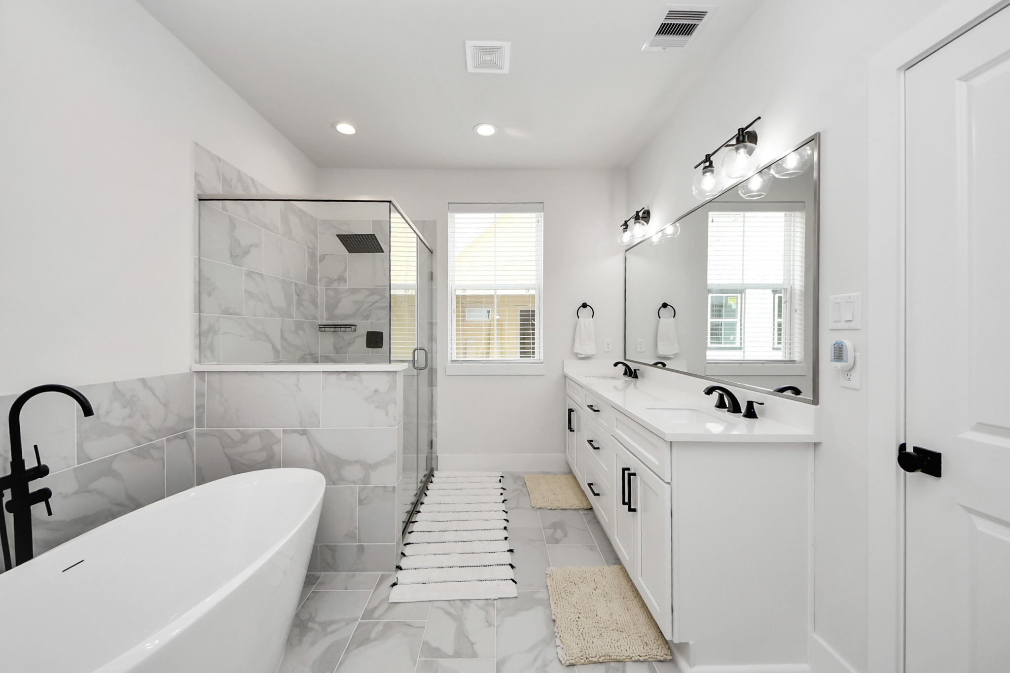 5502 Wheatley Street, Unit B Houston, TX 77091 - Photo 26 of 35 a bathroom with a double vanity sink a large mirror and bathtub
