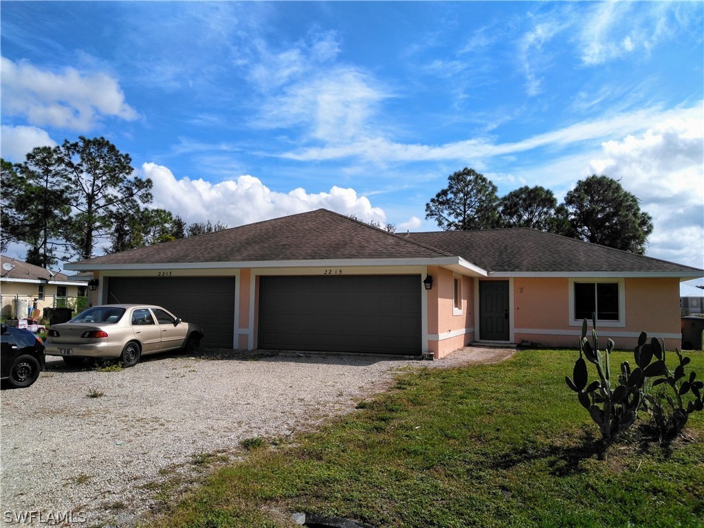 2213 Wilson Road Lehigh Acres, FL 33973 - Photo 1 of 14 a couple of cars parked in front of a house