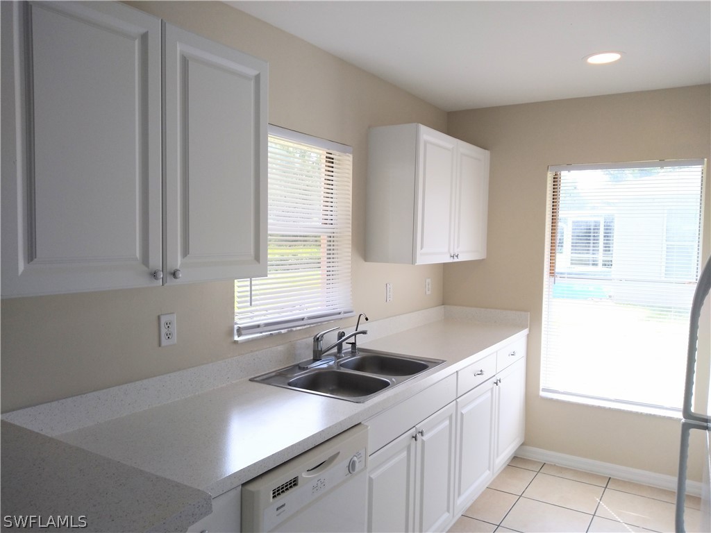 2213 Wilson Road Lehigh Acres, FL 33973 - Photo 3 of 14 a kitchen with a sink cabinets and window