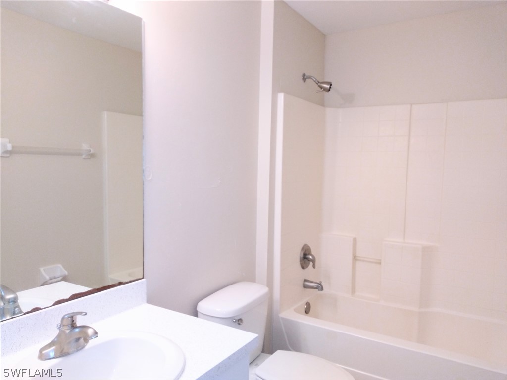 2213 Wilson Road Lehigh Acres, FL 33973 - Photo 9 of 14 a bathroom with a bathtub shower sink vanity and toilet