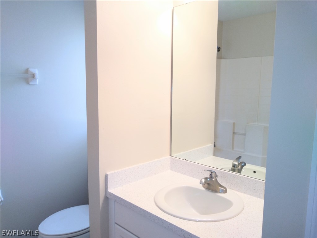 2213 Wilson Road Lehigh Acres, FL 33973 - Photo 10 of 14 a bathroom with a sink and a mirror