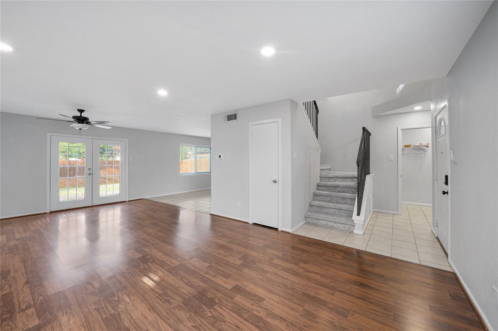 9227 Pinewood Drive Dallas, TX 75243 - Photo 2 of 27 a view of an empty room with wooden floor and windows