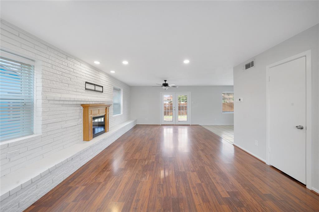 9227 Pinewood Drive Dallas, TX 75243 - Photo 3 of 27 a view of empty room with wooden floor and fireplace