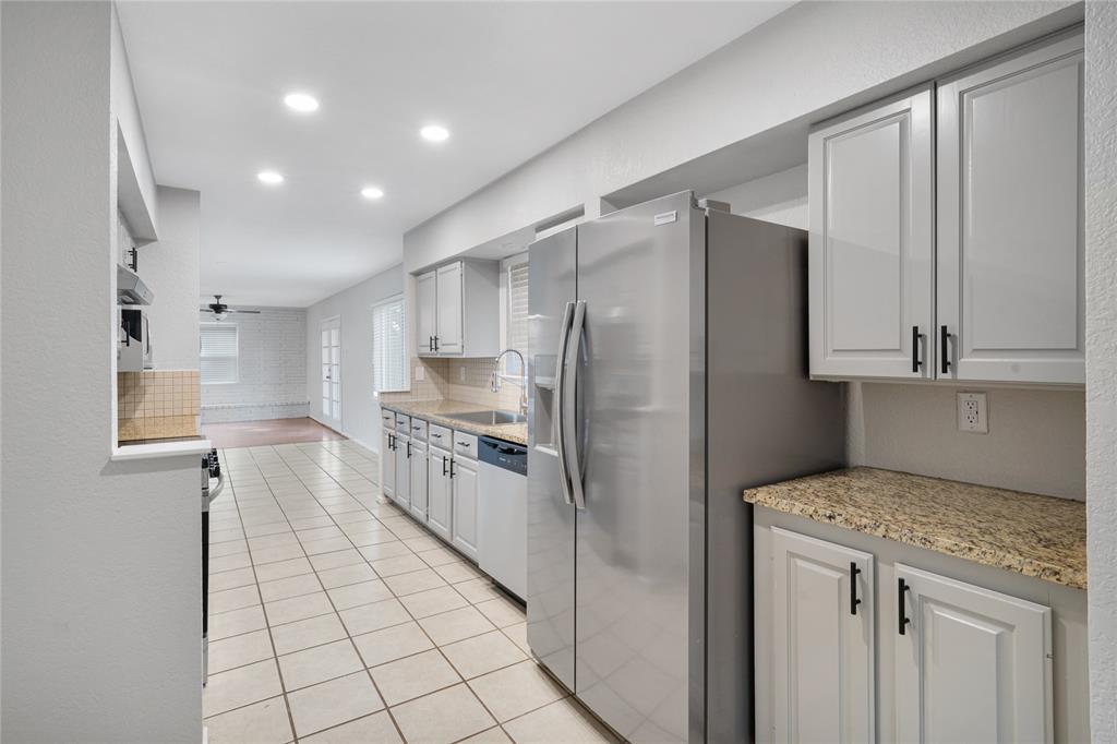 9227 Pinewood Drive Dallas, TX 75243 - Photo 9 of 27 a kitchen with a refrigerator sink and cabinets