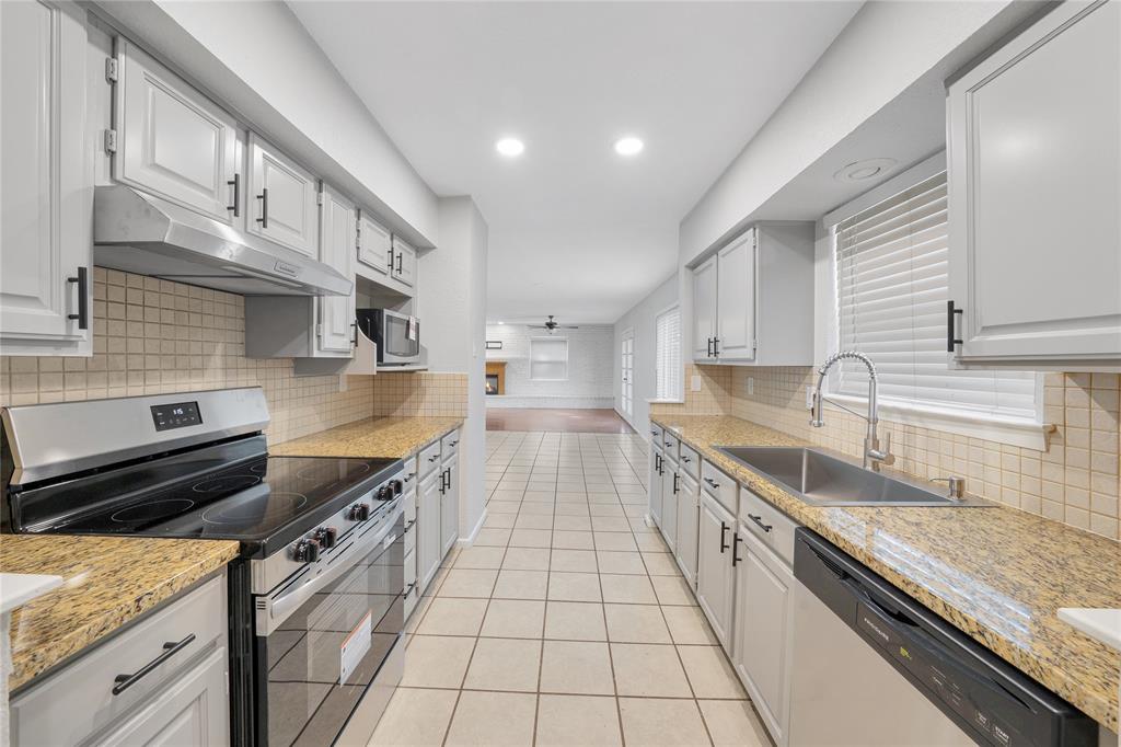 9227 Pinewood Drive Dallas, TX 75243 - Photo 10 of 27 a large kitchen with stainless steel appliances granite countertop a stove a sink and a white cabinets