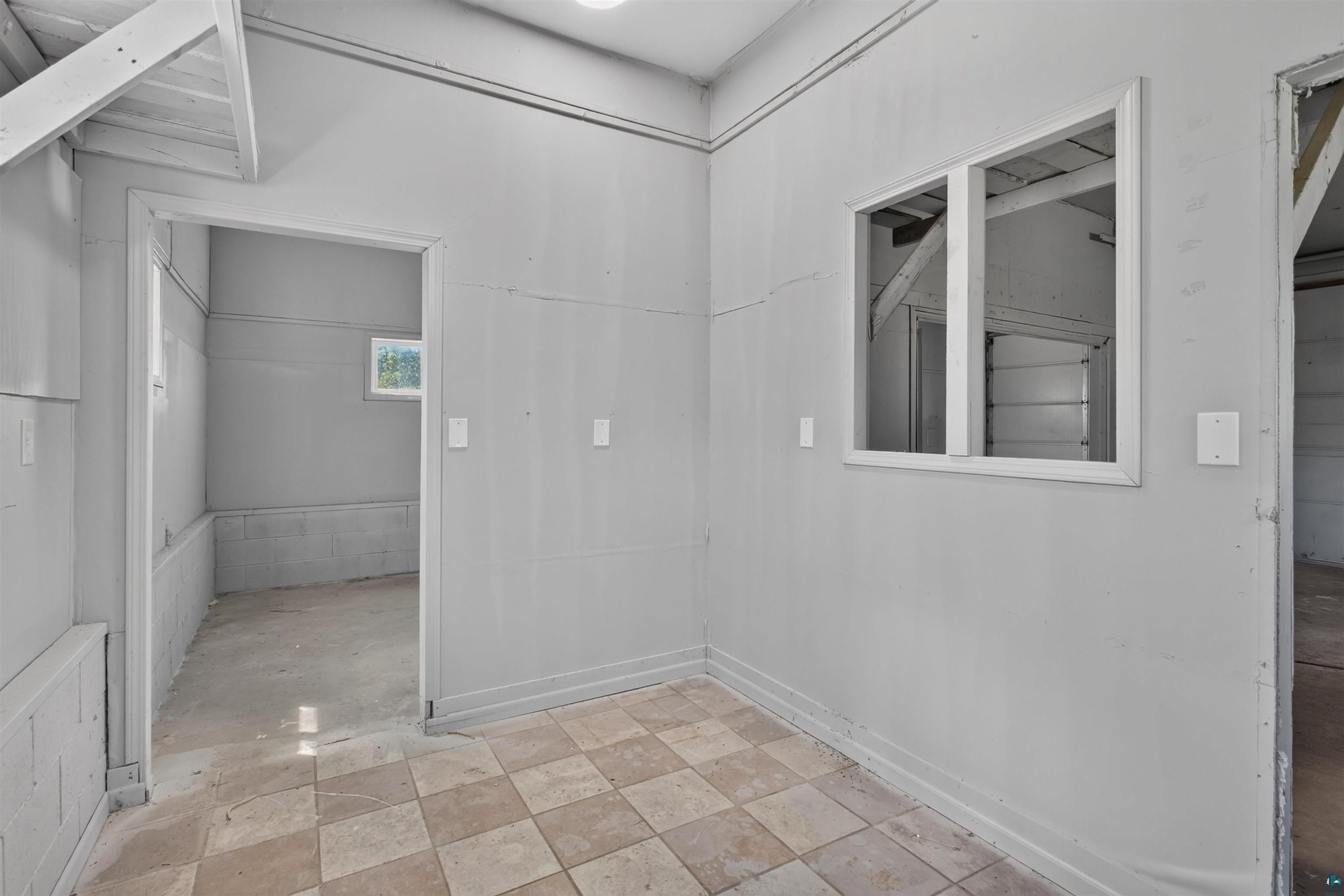 5868 Rice Lake Road Duluth, MN 55803 - Photo 32 of 39 Interior space featuring checkered floor tile, painted walls, and exposed ceiling beams