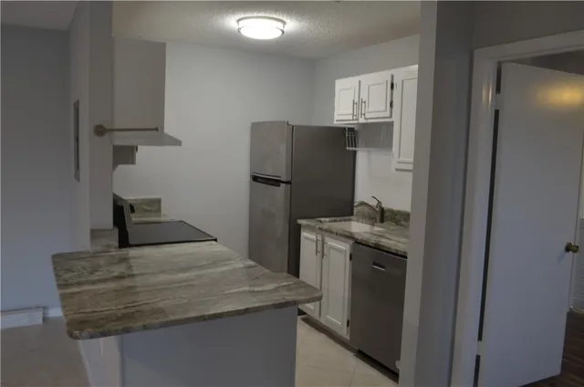 a kitchen with stainless steel appliances granite countertop a sink stove and cabinets