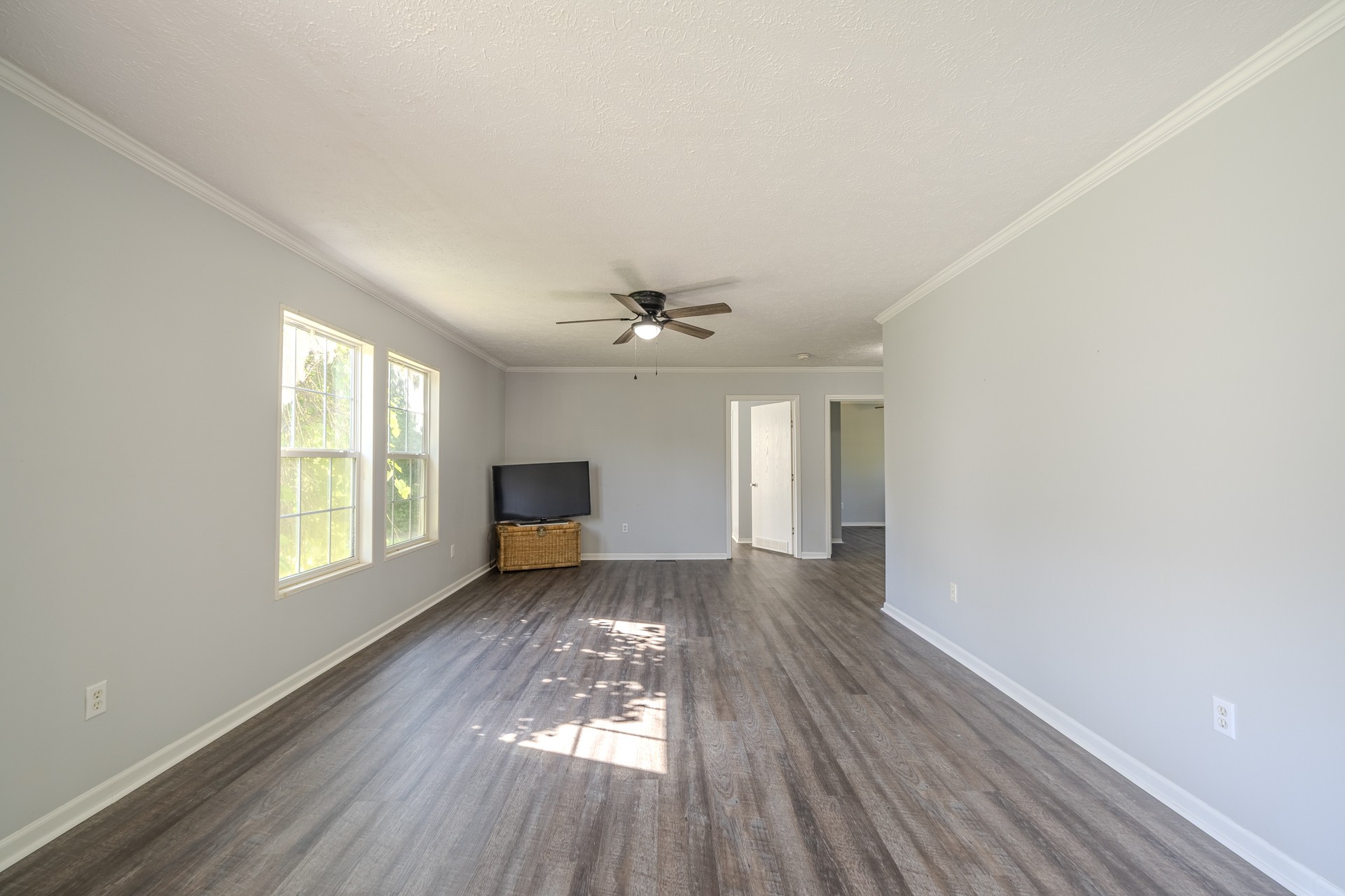 1125 Clifft Road Bolivar, TN 38008 - Photo 32 of 78 an empty room with wooden floor chandelier fan and windows
