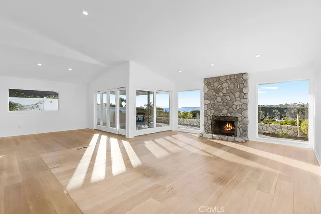 a view of an empty room with a fireplace and a window