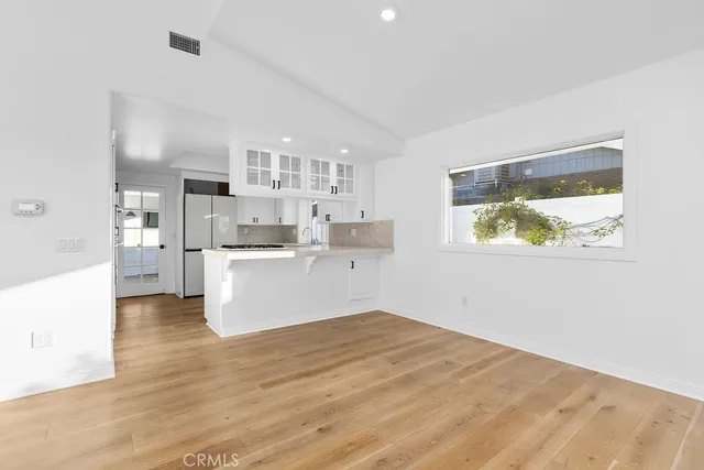 a kitchen with white cabinets and appliances