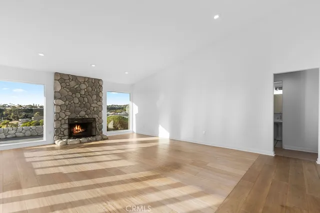 a view of a big room with wooden floor and windows