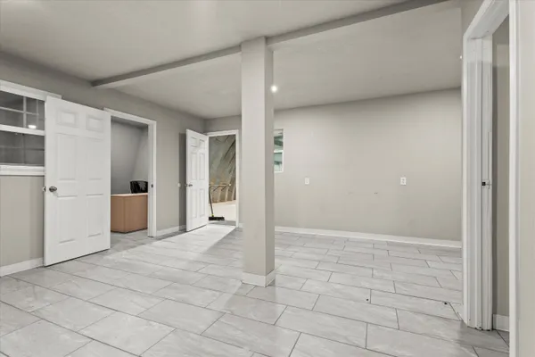 a view of a hallway with some storage area and a refrigerator