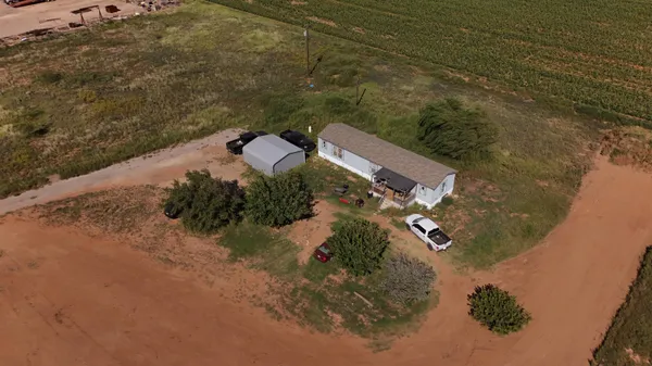 an aerial view of a house with a yard and ocean view