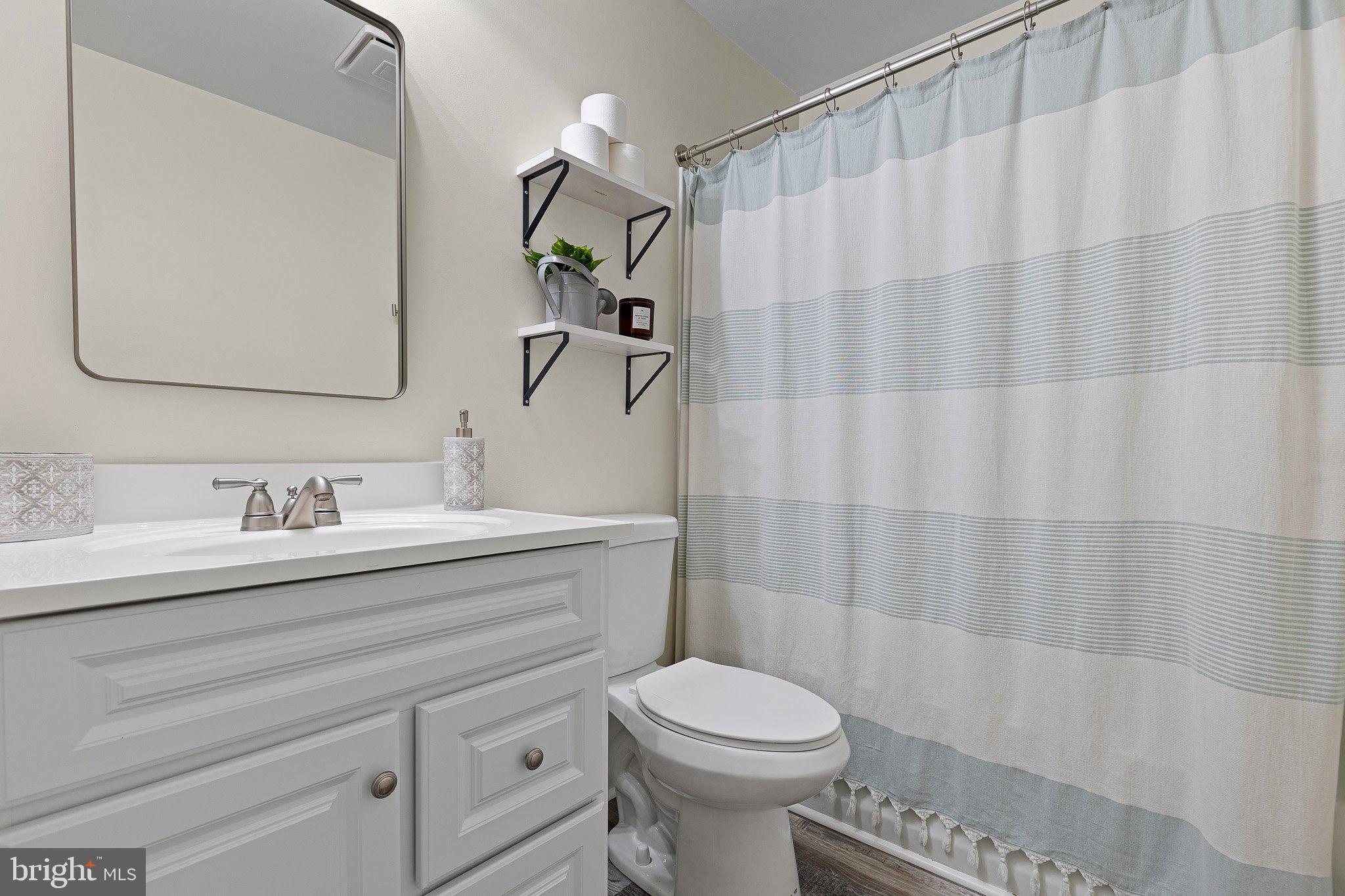 370 Big Elk Chapel Road Elkton, MD 21921 - Photo 21 of 29 a bathroom with a granite countertop sink a toilet and a mirror