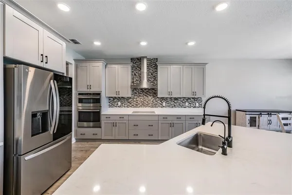 a kitchen with a stove a refrigerator and a sink