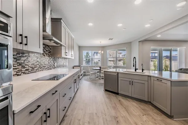 a kitchen with stainless steel appliances sink a stove and cabinets