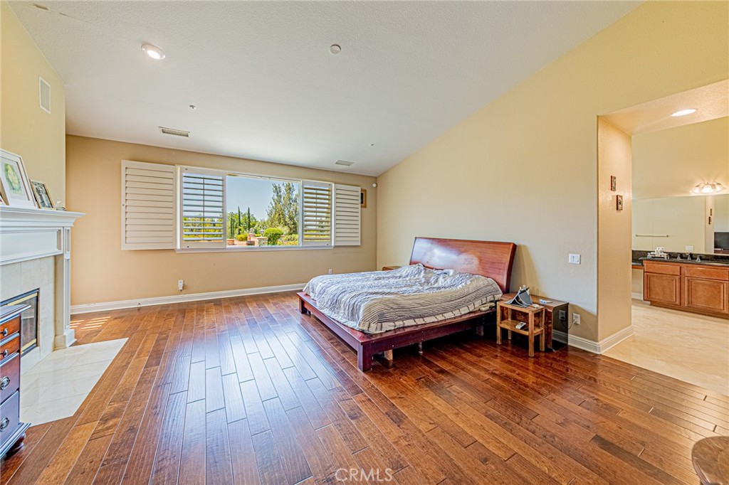 4088 Shady Ridge Circle Corona, CA 92881 - Photo 33 of 47 a bedroom with a bed and wooden floor