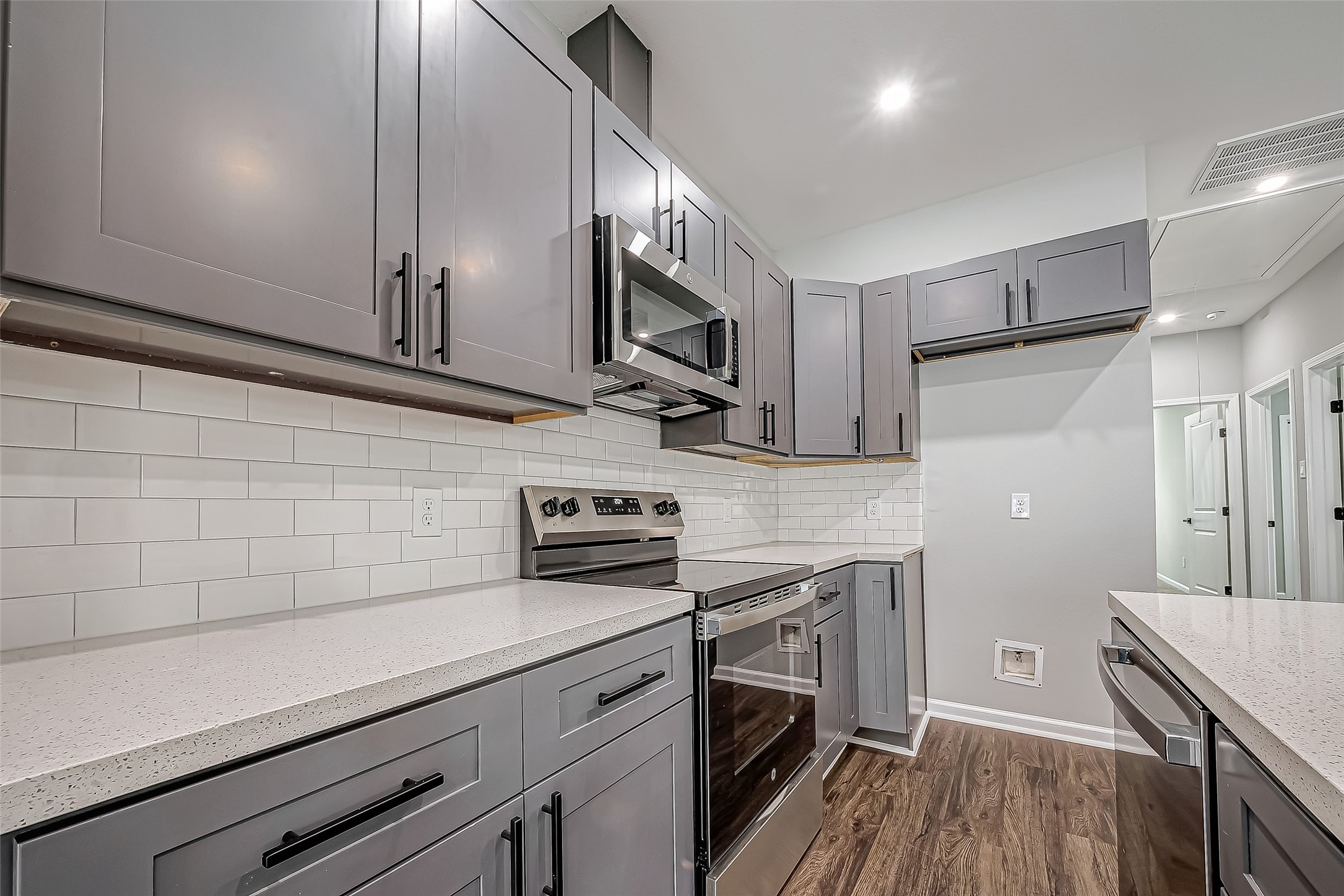 7234 St Augustine Street, Unit A Houston, TX 77021 - Photo 11 of 20 a kitchen with stainless steel appliances a sink dishwasher a stove top oven a refrigerator with wooden floors and cabinets