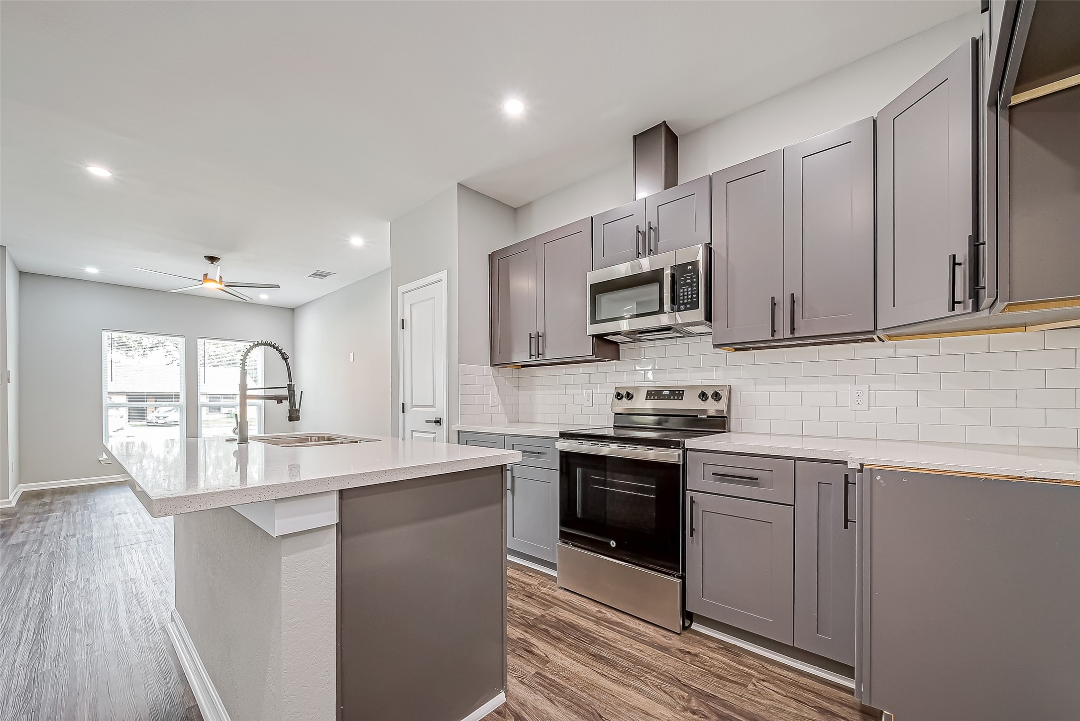 7234 St Augustine Street, Unit A Houston, TX 77021 - Photo 10 of 20 a kitchen with kitchen island granite countertop a sink stainless steel appliances and cabinets